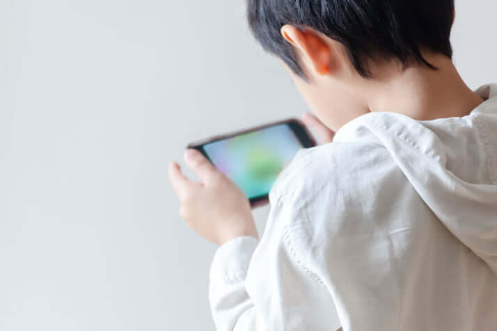 スマホをいじる男の子イメージ