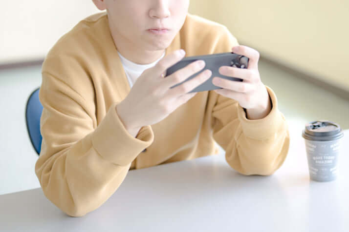 スマホゲームをする男の子